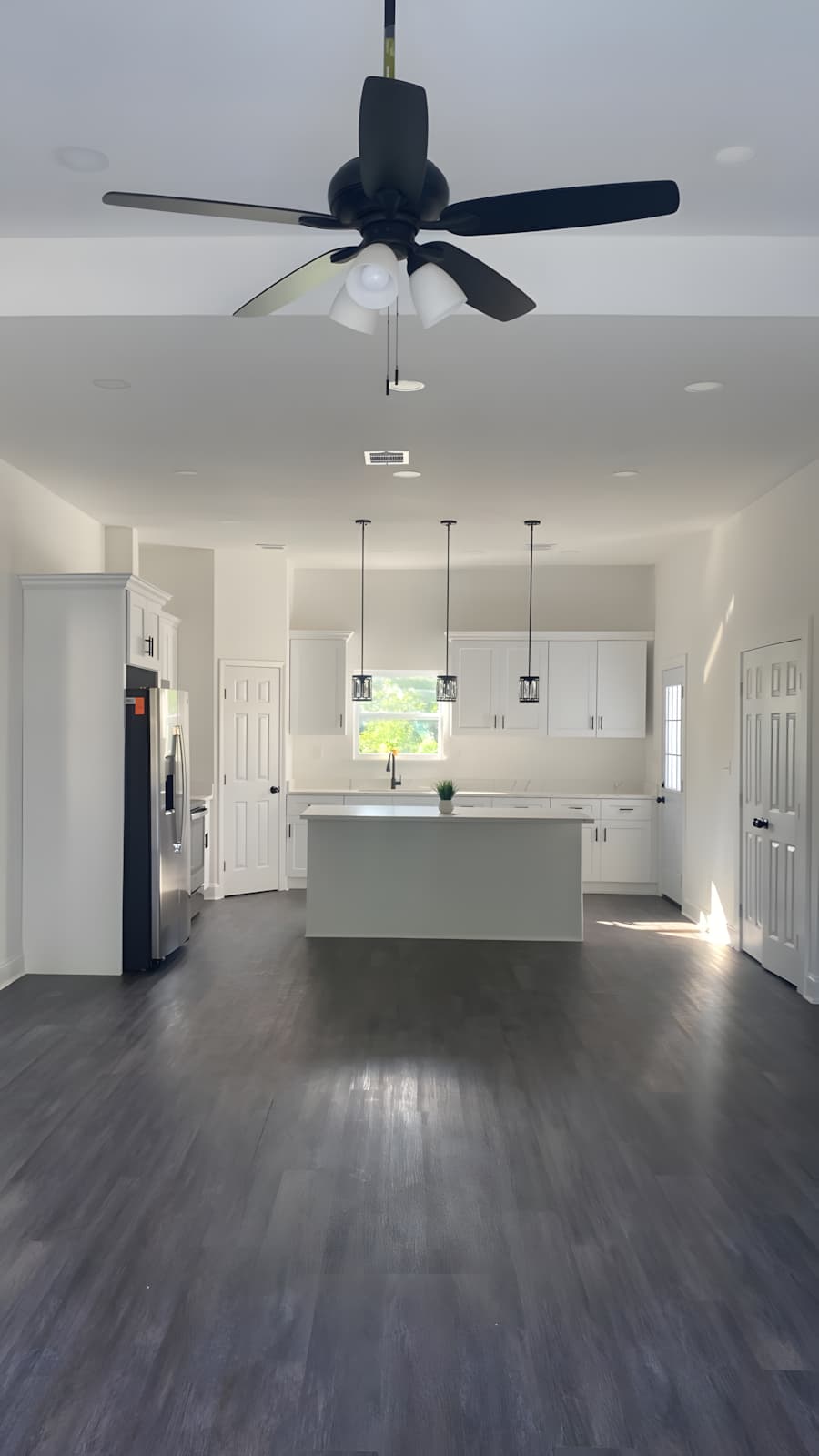 Renovated open-plan kitchen with a white island and dark wood floor